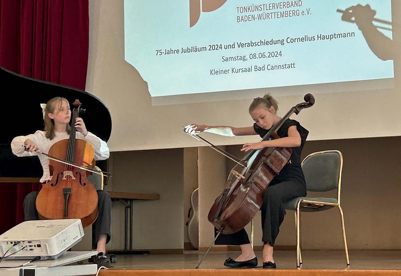 Zwei Mädchen spielen Cello.