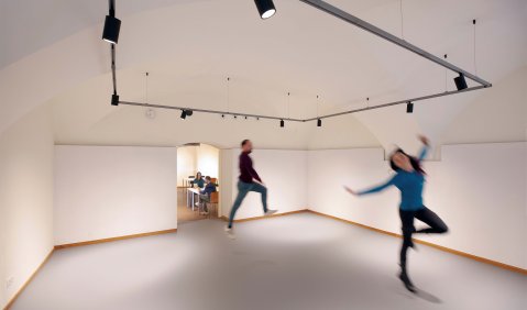 Zwei Personen tanzen verschwommen abgebildet durch einen Raum.
