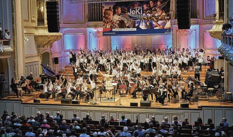 Ein Orchester spielt in der mit JeKi-Transparent und Beleuchtung geschmückten Laeiszhalle.