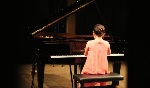 Ein Mädchen im rosa Kleid an einem Bechstein-Flügel